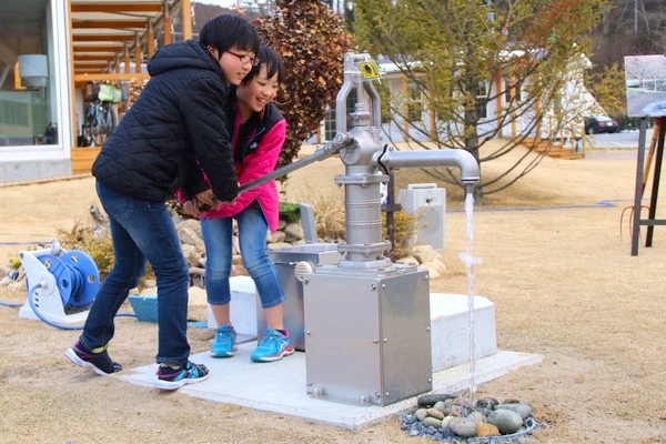 女川駅前広場に設置されたコミュニティ井戸を利用する子どもたち1